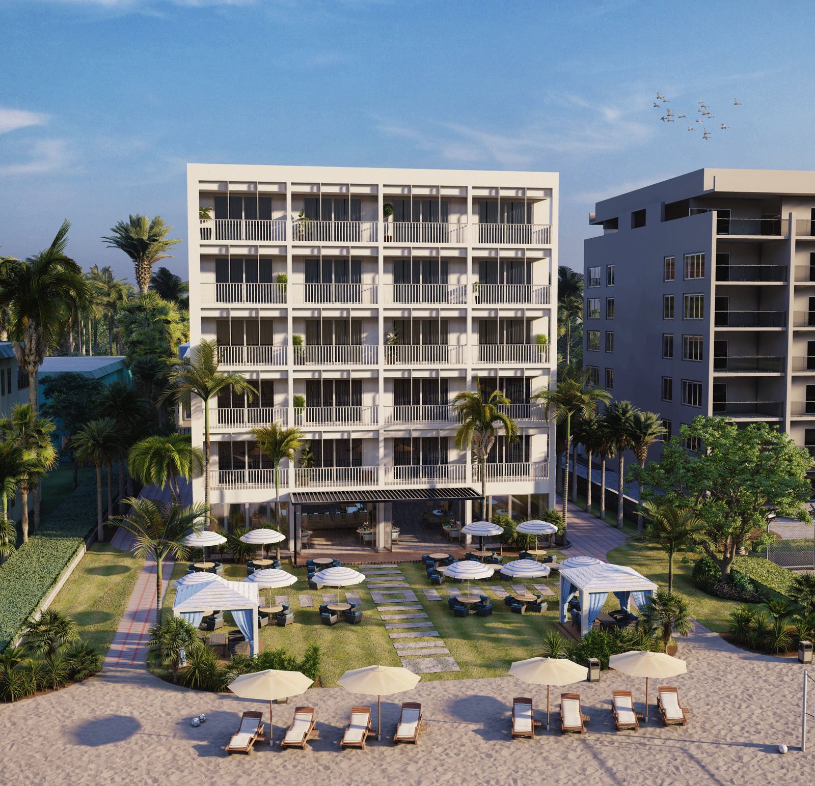 Modern beachfront hotel with multiple balconies, palm trees, landscaped courtyard, outdoor seating, cabanas, and sun loungers facing sandy beach under clear blue sky.