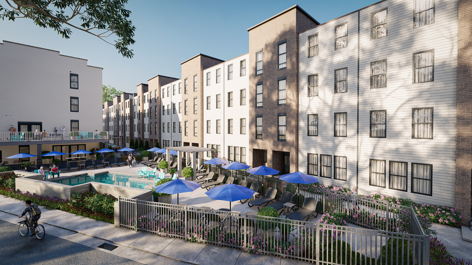 Modern multi-family apartment complex with landscaped courtyard, outdoor swimming pool, lounge seating with blue umbrellas, and street-side view with cyclist in foreground.