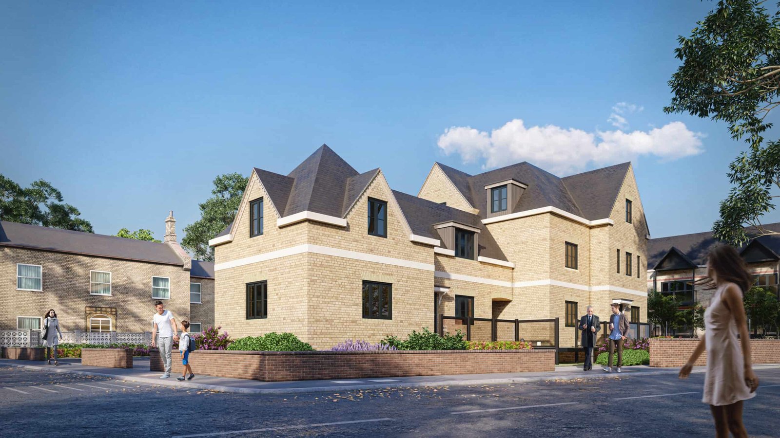 Beige brick apartment buildings with steep gabled roofs on a landscaped corner lot, with pedestrians walking along the sidewalk on a sunny day.