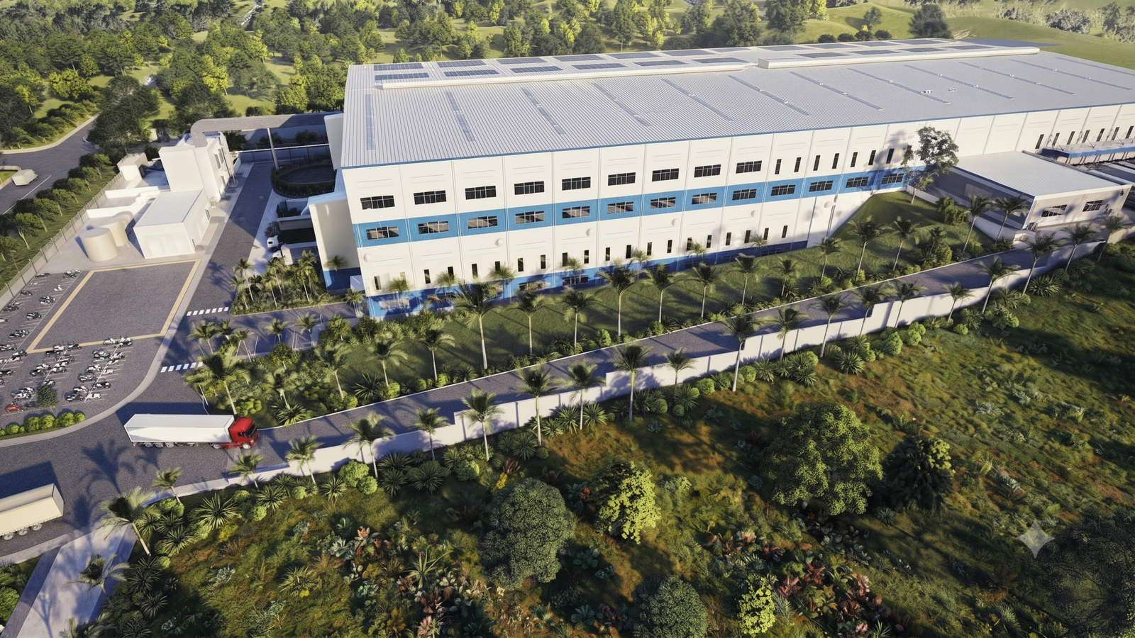 Bird's-eye view of long warehouse building with parking area and mature trees framing the structure
