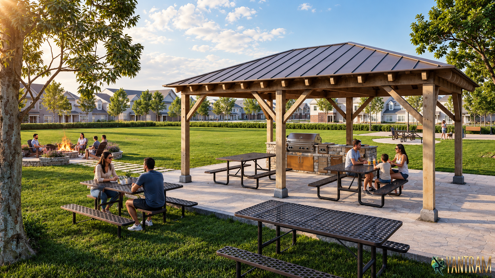 Wooden park pavilion with metal roof, picnic tables, built-in barbecue grill, fire pit seating area, and open green lawn in a residential neighborhood.