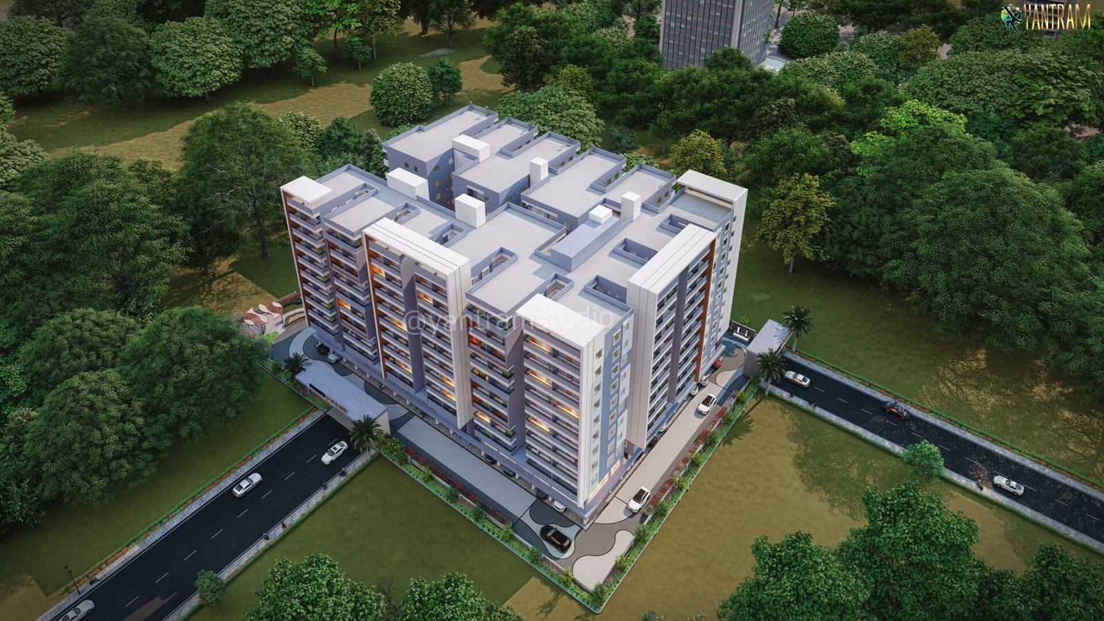 Aerial 3D rendering of a residential apartment complex surrounded by greenery and road infrastructure. – 3D rendering by Yantram Studio